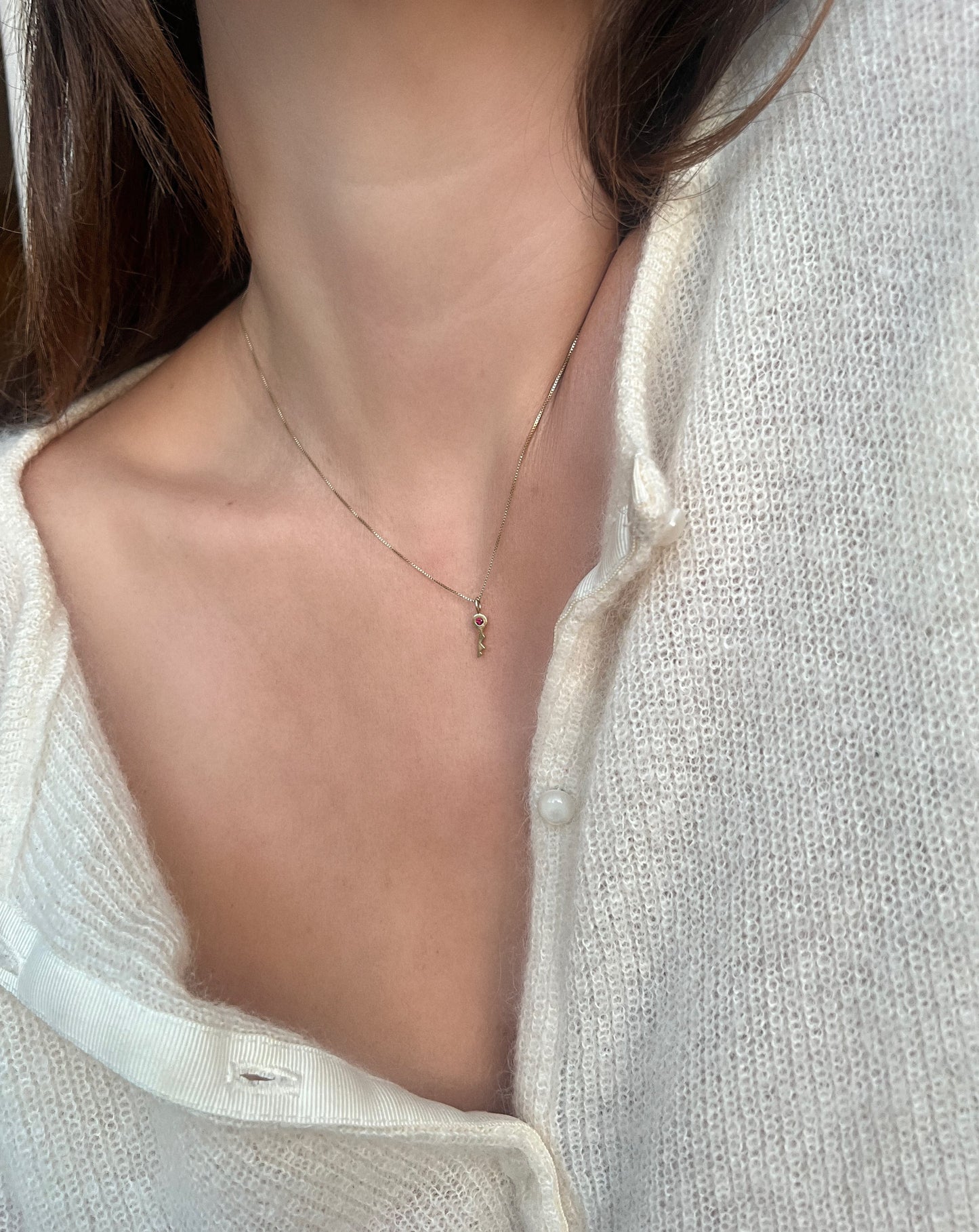 Collar con dije de llave de rubí de 18 quilates